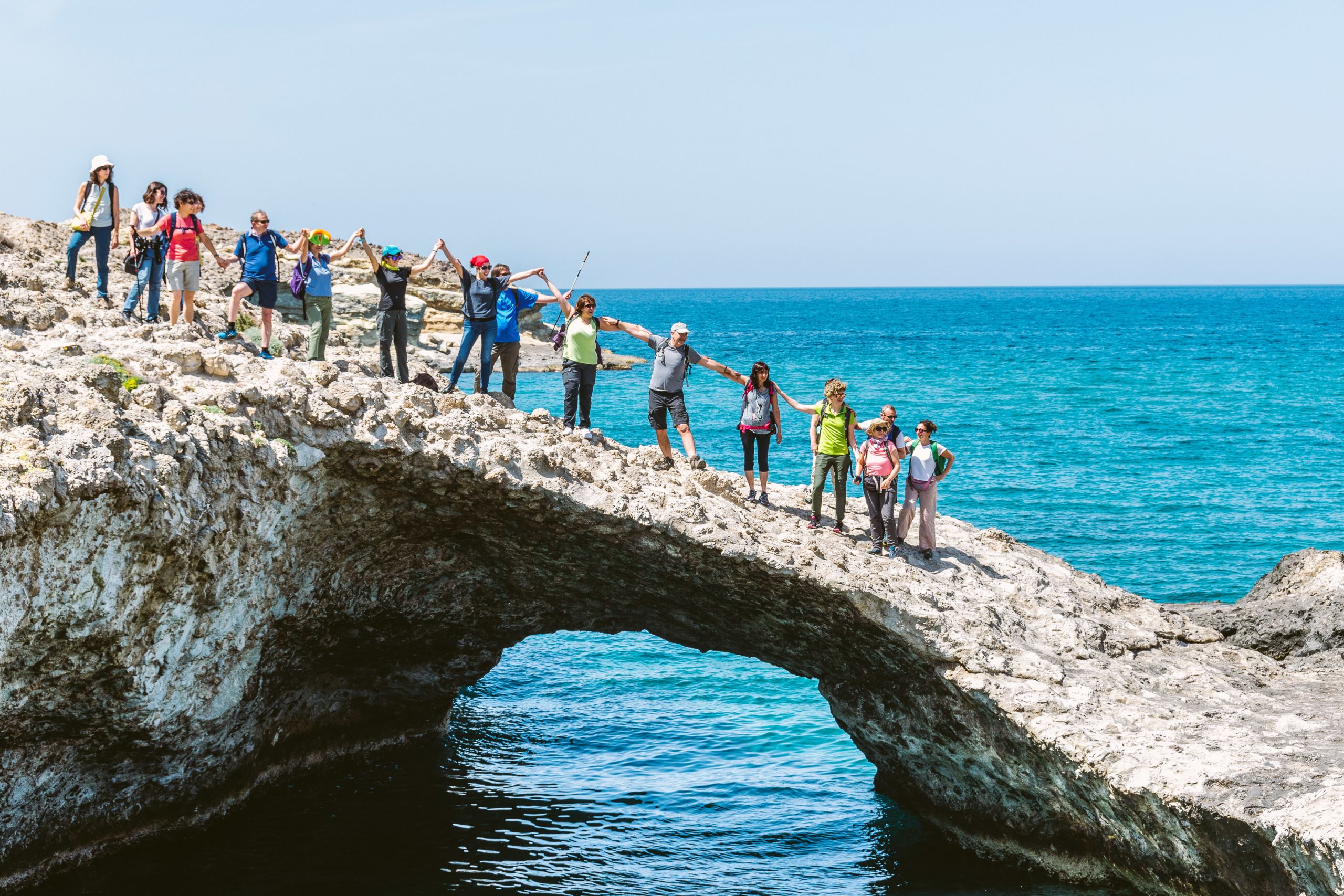 Gruppo durante un trekking su un ponte di pietra sopra una gola, itinerario escursionistico in Grecia con Girolibero nelle Cicladi Minori